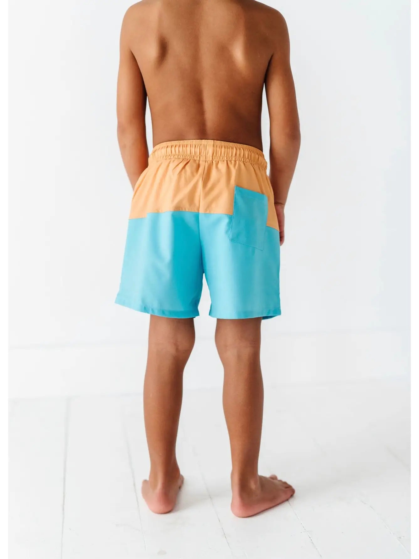 back of boy wearing swim trunks with back pocket