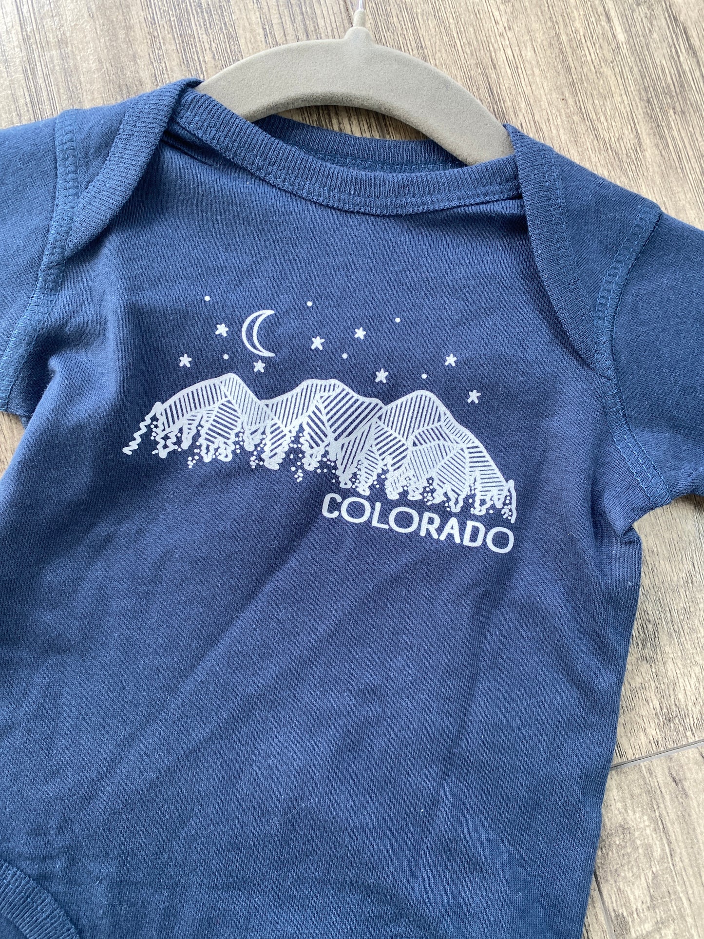 detail graphic of colorado night sky on baby onesie