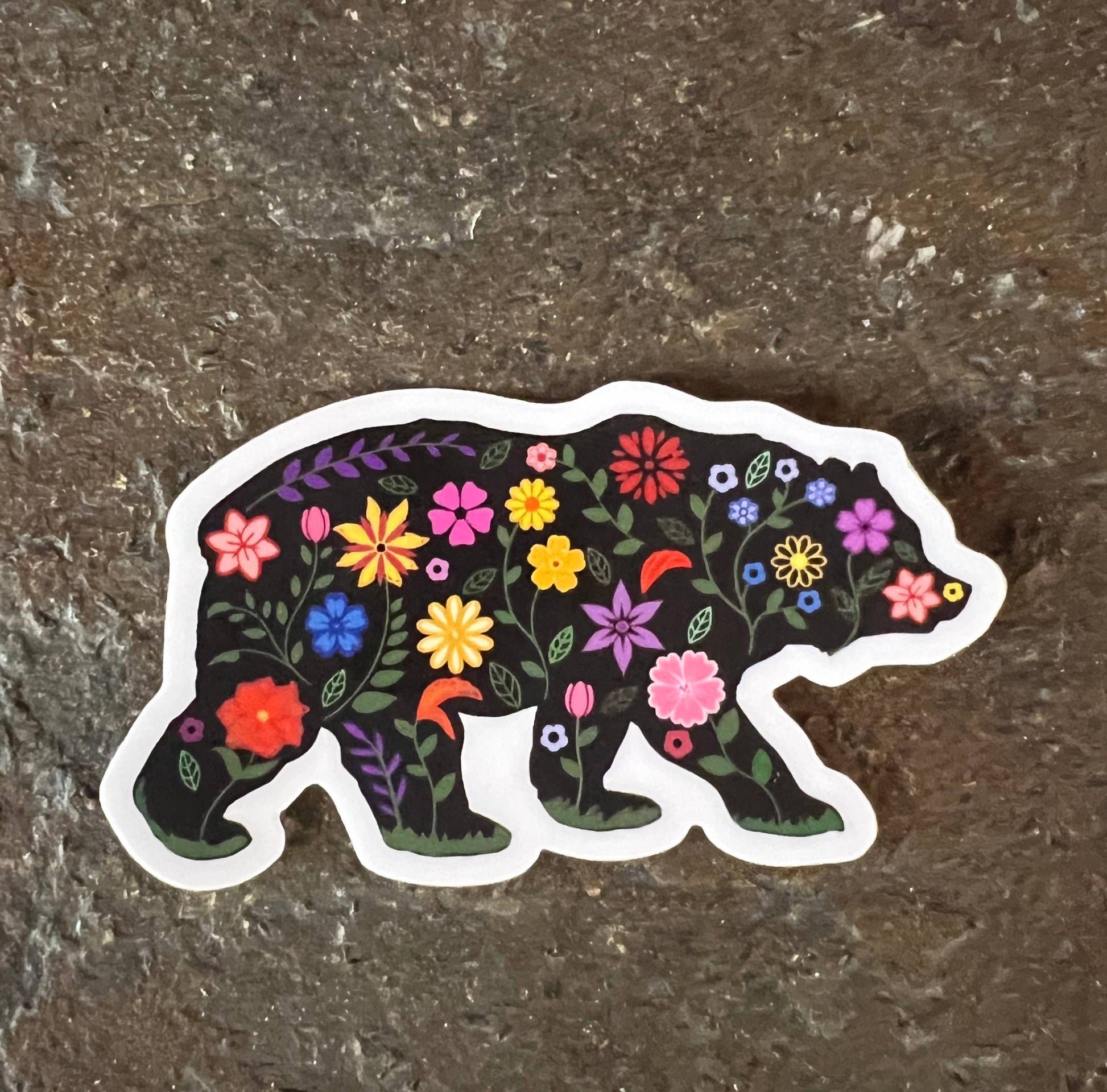 Sticker of a bear with floral design on a textured surface