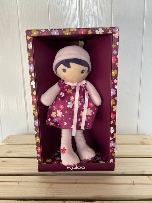 soft plush toy doll with dark hair and purple dress with flowers